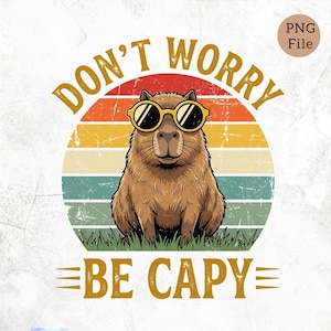 May include: A brown capybara wearing sunglasses, sitting on grass, with a retro sunset background. The text reads "DON'T WORRY BE CAPY" in a vintage style font. The image has a distressed, aged look.