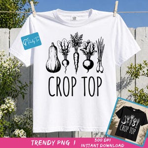 Może przedstawiać: Biała koszulka z czarną grafiką przedstawiającą różne warzywa, w tym dynię, buraki, marchew i cebulę. Słowa "CROP TOP" są wydrukowane pogrubioną, czarną czcionką pod warzywami. Koszulka wisi na sznurku do prania.