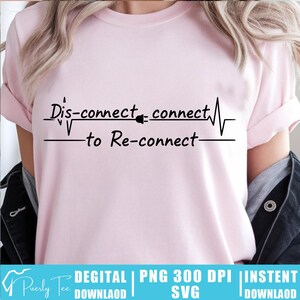 May include: A light pink t-shirt with the text "Dis-connect - connect - to Re-connect" in black. The design includes a heartbeat line and a plug icon. The shirt is a casual wear item.