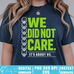 Puede incluir: Camiseta azul marino con el texto "WE DID NOT CARE." en verde brillante. Una fila vertical de calaveras blancas está a la izquierda. Debajo está escrito "IT'S ABOUT US."