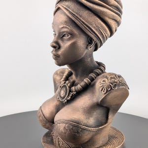 Bronze-toned African sculpture bust of a regal Black woman in a layered headwrap with beaded necklace; decorative home decor for mantel or living room.