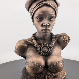 Bronze-toned African sculpture bust of a regal Black woman in a layered headwrap with beaded necklace; decorative home decor for mantel or living room.
