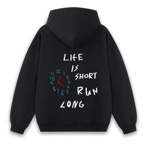 May include: Black hooded sweatshirt with a white graphic print that says "Life is short run long" with a clock face and hands in blue and red.