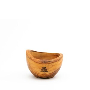 Peut inclure: Un bol en bois avec une forme incurvée et un grain de bois naturel. Le bol est en bois d'olivier et porte les mots "Golden Earth" gravés au fond.