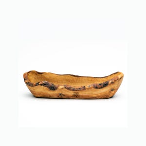 Peut inclure: Un grand bol de service en bois de forme ovale avec une finition en bois naturel. Le bol a un aspect rustique et artisanal et est fait de bois d'olivier. Le bol est vide et prêt à être rempli de nourriture.