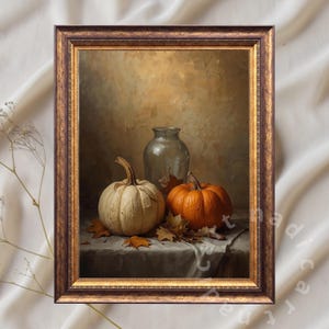 Peut inclure: Peinture encadrée de nature morte avec une citrouille blanche et une citrouille orange, un vase en verre et des feuilles d'automne. L'œuvre a une palette de couleurs chaudes avec des tons bruns et dorés, créant un thème automnal chaleureux.