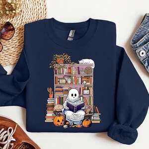 a blue sweatshirt with a skeleton reading a book