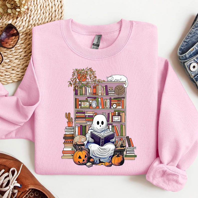 a pink shirt with a ghost reading a book