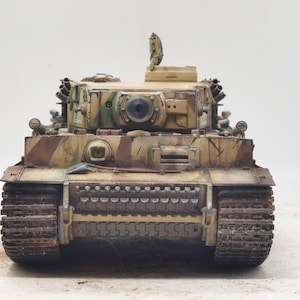 May include: A detailed model of a German Tiger I tank, painted in a camouflage pattern of green, brown, and tan. The tank has a large gun turret and tracks.