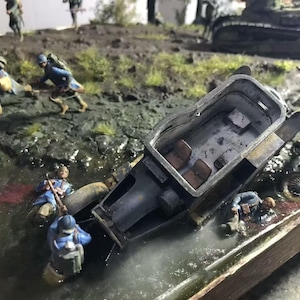May include: A detailed diorama depicting a World War I scene with miniature soldiers in blue uniforms, a damaged tank, and a small vehicle. The scene is set in a muddy environment with water and vegetation.