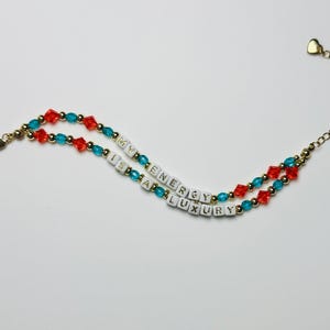 Mi energía es lujo: pulsera de afirmación energética con cuentas en color verde azulado, naranja y dorado.