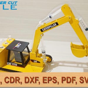 May include: A yellow Caterpillar 225D hydraulic excavator model constructed from laser-cut parts. The mechanical arm is operated by clear plastic syringes connected with tubing. The cab is black with yellow accents, and the text LASER CUT FILE and Ai, CDR, DXF, EPS, PDF, SVG are visible.