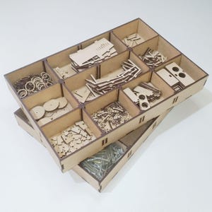 K&ouml;nnte beinhalten: Ein lasergeschnittener Datei-Organizer mit mehreren F&auml;chern, die mit Holzteilen und Hardware gef&uuml;llt sind. Der Text "LASER CUT FILE" und "NO PHYSICAL PRODUCT" ist in Blau dargestellt.