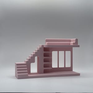 May include: A light pink architectural model featuring stairs, shelves, and a windowed structure. The model has a flat roof and a rectangular base. The design is minimalist and geometric, with clean lines and a solid colour.
