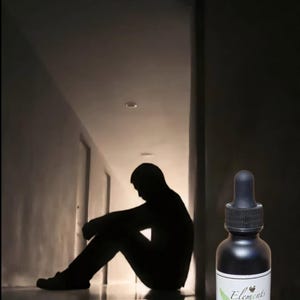 May include: A black bottle with a dropper, labeled "Elements Restoring Nature," is positioned next to a silhouette of a person sitting in a hallway. The image is dark, with the person's form in shadow.