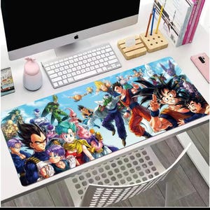 Puede incluir: Alfombrilla de ratón rectangular con una vibrante ilustración de personajes de Dragon Ball. El diseño presenta varios personajes sobre un fondo de cielo azul. La alfombrilla está colocada sobre un escritorio blanco.