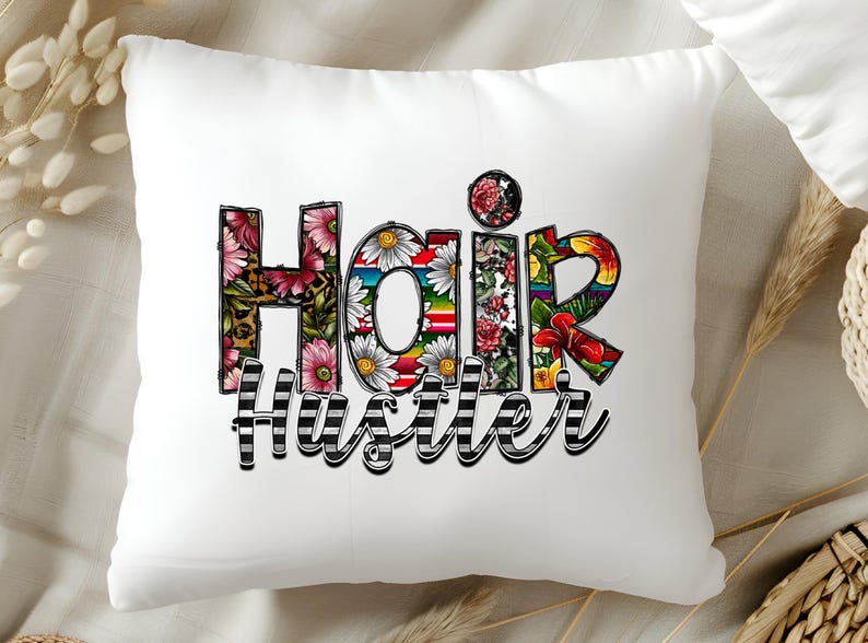 May include: White pillow with the words "Hair Hustler" in colorful letters with floral designs. The letters are outlined in black and white stripes.
