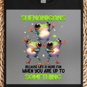 May include: A gray t-shirt with a green frog design. The frogs are dancing and the text reads "Shenanigans because life is more fun when you are up to something."