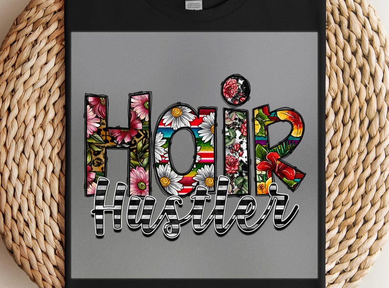 May include: A black t-shirt with a colorful floral design that spells out "Hair Hustler".