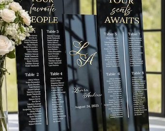 Könnte beinhalten: Schwarze Acryl-Tischkarten mit goldener Beschriftung für einen Hochzeitsempfang. Die Karten listen die Namen der Gäste auf, die jedem Tisch zugewiesen sind. Die Karten sind mit den Tischnummern 1 bis 8 beschriftet. Die Karten enthalten auch die Namen Laura und Andrew sowie das Datum 24. August 2025.