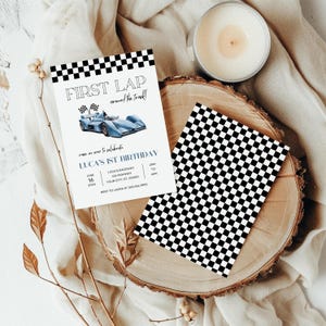 Puede incluir: Una invitación con un patrón de cuadros negros y blancos para una fiesta de primer cumpleaños. La invitación presenta un coche de carreras azul y el texto "Primera vuelta alrededor de la pista!" y "El 1er cumpleaños de Luca".