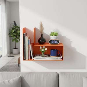 May include: An orange wall-mounted shelf with books, a black vase, a small succulent, a digital clock displaying 10:30 AM, a blue mug, and a small bouquet of white flowers. The shelf is mounted on a white wall.