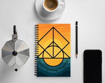 May include: A spiral bound notebook with a yellow, orange, and blue sunset design. The notebook has a black geometric design with the text "Keep Pursuing Progress".