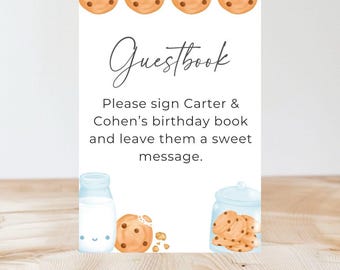 Könnte beinhalten: Eine weiße Karte mit dem Text "Guestbook" in Kursivschrift. Unter dem Text steht eine Nachricht, die lautet: "Bitte unterschreiben Sie das Geburtstagsbuch von Carter & Cohen und hinterlassen Sie ihnen eine süße Nachricht." Die Karte ist mit Keksen und Milch verziert.