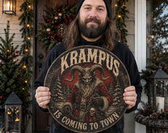 May include: A circular wooden sign featuring a detailed illustration of Krampus with large horns, a red coat, and chains. The text KRAMPUS IS COMING TO TOWN is printed in a distressed font around the central figure against a dark forest background.