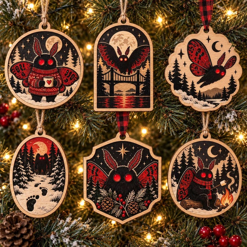 May include: A set of six wooden ornaments featuring moth-like creatures with red eyes and wings. The designs include a moth in a sweater, a moth flying over a bridge, a moth in flight, a snowy forest path with footprints, a moth with pinecones, and a moth by a campfire.