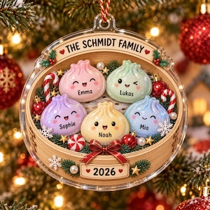 May include: A clear circular Christmas ornament featuring a bamboo steamer design containing five pastel-colored dumpling characters with faces. The text reads THE SCHMIDT FAMILY and 2026. Names Emma, Lukas, Sophie, Noah, and Mia are printed on each dumpling.