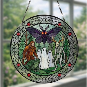 May include: Round stained glass window featuring a forest scene with a purple moth, Bigfoot, ghosts, a skeleton with antlers, and a green frog. The window is framed with a black border and red accents, and is suspended by a chain.