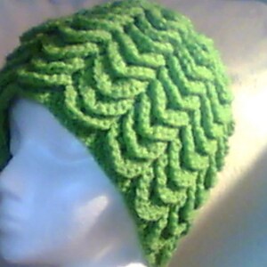 May include: A bright green crocheted hat with a textured, wave-like pattern. The hat is made of soft yarn and has a unique, eye-catching design. This handmade hat is a stylish accessory.