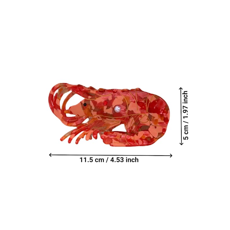 Pode incluir: Um prendedor de cabelo em forma de lagosta vermelho e laranja com um detalhe de p&eacute;rola. O prendedor mede 11,5 cm de largura e 5 cm de altura.