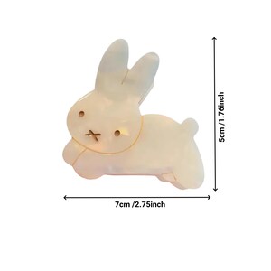 May include: A white ceramic bunny rabbit figurine with a simple design. The figurine is 2.75 inches wide and 1.76 inches tall.