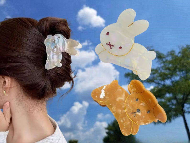 May include: Three hair clips in the shape of animals. One is a white bunny, one is a brown bear, and one is a white bunny with iridescent details.