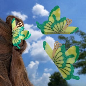 May include: Three green and yellow butterfly hair clips. The butterfly clips have a green and yellow glitter finish.