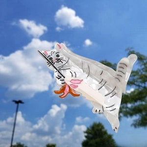 May include: A white cat-shaped hair claw clip with a translucent finish, featuring black line details for the face and body, pink accents on the ears and paws, and a small orange starfish held by the cat, constructed from smooth acrylic material.