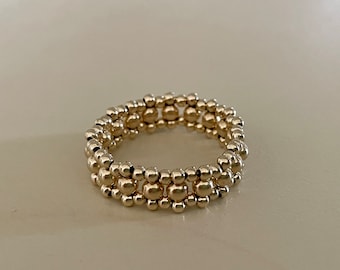 Mönster med tunn pärlring i guld
