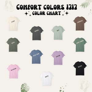 May include: A Comfort Colors 1717 color chart featuring eleven short-sleeve t-shirts in various colors including ivory, pepper, bay, expresso, moss, light green, blue jean, orchid, blossom, white, and black, each labeled with its respective color name.