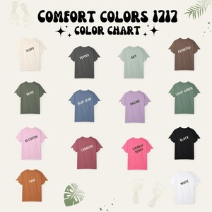 Może przedstawiać: Wzornik kolor&oacute;w Comfort Colors 1717 przedstawiający czternaście koszulek z kr&oacute;tkim rękawem w r&oacute;żnych odcieniach, w tym kość słoniowa, pieprz, zatoka, espresso, mech, niebieski dżins, orchidea, jasna zieleń, kwiat, karmazyn, crunch berry, czerń, biel i ignam.