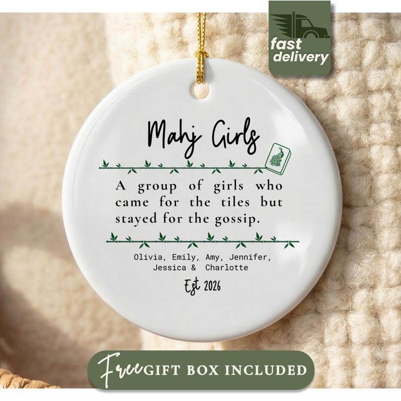 May include: A round white ceramic ornament featuring the text Mahj Girls, a small green tile icon, and the phrase A group of girls who came for the tiles but stayed for the gossip. It includes the names Olivia, Emily, Amy, Jennifer, Jessica, Charlotte and Est 2026.