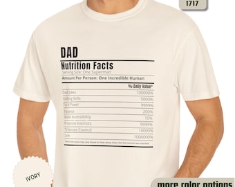 Könnte beinhalten: Elfenbeinfarbenes T-Shirt mit dem Text "DAD Nutrition Facts". Die Grafik listet humorvolle "% Tageswert" für Eigenschaften wie Papa-Witze, Grillkünste und Liebe auf. Das Shirt hat auch den Text "Comfort Colors 1717" und "more color options."