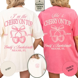 May include: Ivory and Crunch Berry t-shirts with the text "I'm the Cherry on Top" and "She's Cherry on Top" in pink script. The shirts feature a cherry graphic with the text "ES" and "Emily's Bachelorette Miami, FL".