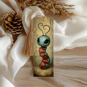 May include: A whimsical bookmark featuring a cartoon caterpillar with a blue head and red and blue body segments. The bookmark has a gold tassel and a decorative illustration of a forest scene. The caterpillar has large, expressive eyes.