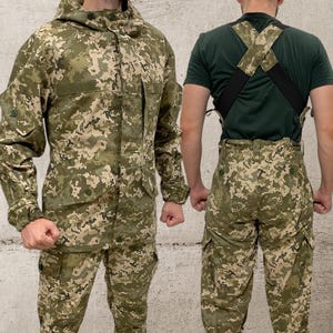 以下が含まれることがあります： フード付きジャケットとマッチするパンツを含む、迷彩柄の軍服セット。 ジャケットには複数のポケットとボタン留めのフロントが付いています。 パンツにはカーゴポケットが付いています。 パターンは緑、ベージュ、茶色の混合です。