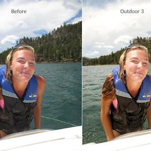 May include: A woman wearing a blue life vest and a pink tank top is standing on a boat. She is smiling and looking at the camera. The background is a lake with trees on the shore.
