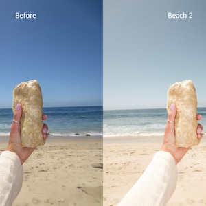 May include: A person holds a large, light brown rock in front of a beach scene with blue water and a sandy shore. The text "Beach 2" is visible in the upper right corner of the image.