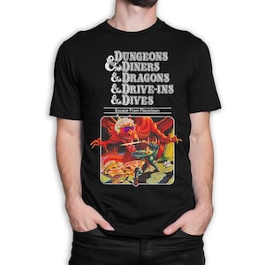 May include: Black t-shirt with a parody Dungeons & Dragons game cover featuring a red dragon and a knight. The text reads "Dungeons & Diners & Dragons & Drive-Ins & Dives. Escape From Flavortown."