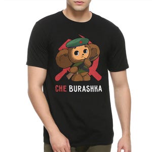 May include: Black t-shirt featuring a cartoon image of a bear wearing a military cap and holding a rifle. The bear is standing in front of a red star and the text "CHE BURASHKA" is printed below the image.